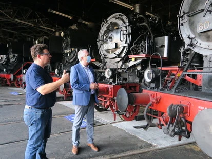 Dr. Noack, Kurator des Schauplatzes Eisenbahn Chemnitz-Hilbersdorf präsentiert Staatsminister Schmidt die beeindruckende Sammlung an Dampfloks in der großen Lokhalle