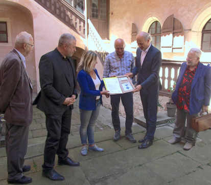 Landrat Michael Geisler und Alf Furkert überreichen im Beisein des Bürgermeisters Hans-Peter Retzler den Fördermittelbescheid an Familie Höhnel und an Dr. Peter Kersten, Ehrenvorsitzender des Vereins "Schwarzes Kleeblatt" e. V.