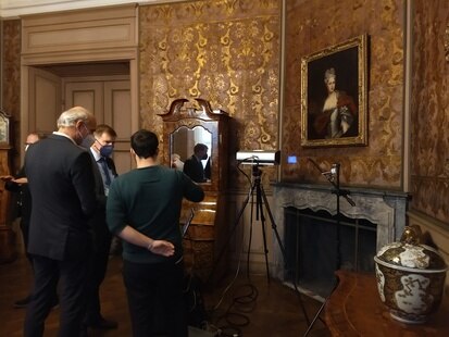 Staatssekretär Dr. Frank Pfeil und Landeskonservator Alf Furkert informieren sich über die zerstörungsfreien Klimamessungen an den kostbaren Goldledertapeten im Schloss Moritzburg 